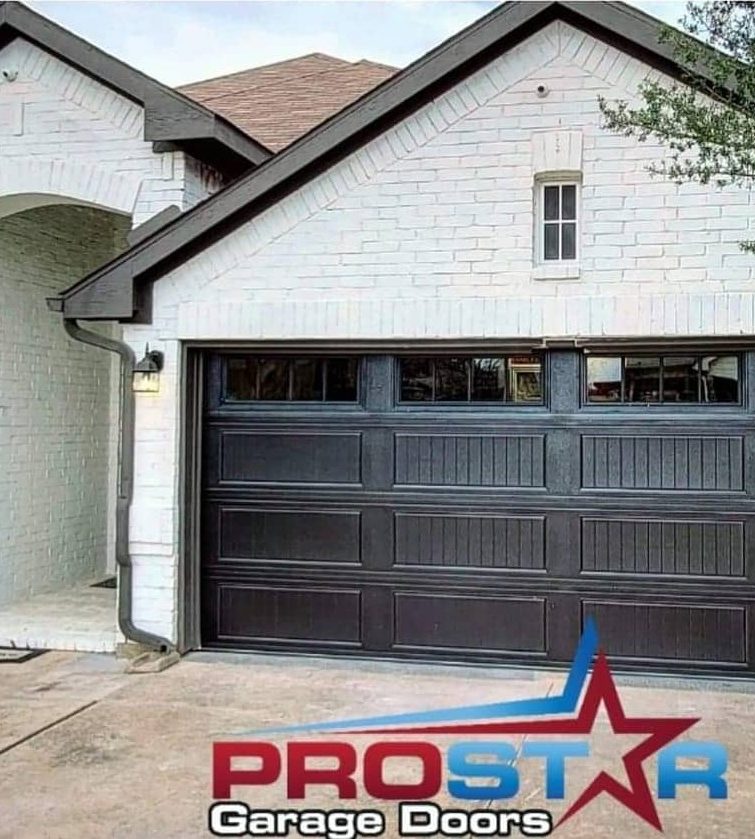 New dark brown double garage door with windows on a white brick home