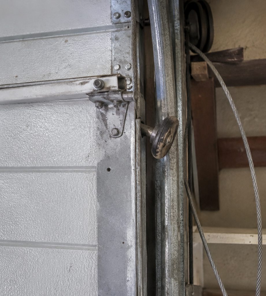 Garage door roller out of its track with a loose lift cable