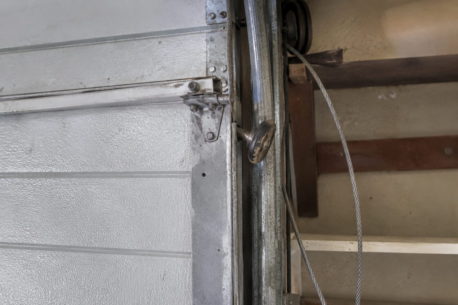 Garage door roller out of its track with a loose lift cable