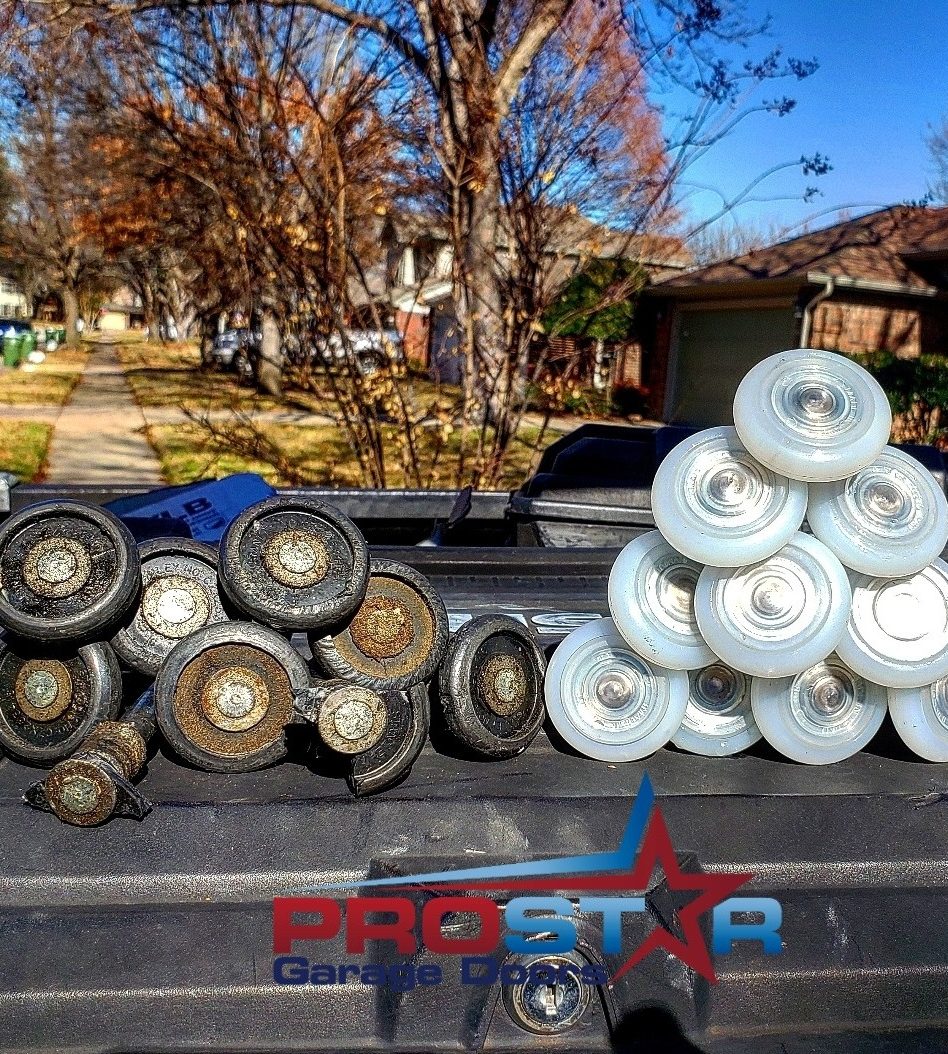 Worn garage door rollers next to new nylon replacement rollers