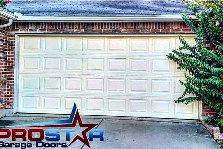 Repaired white raised-panel garage door on a brick home